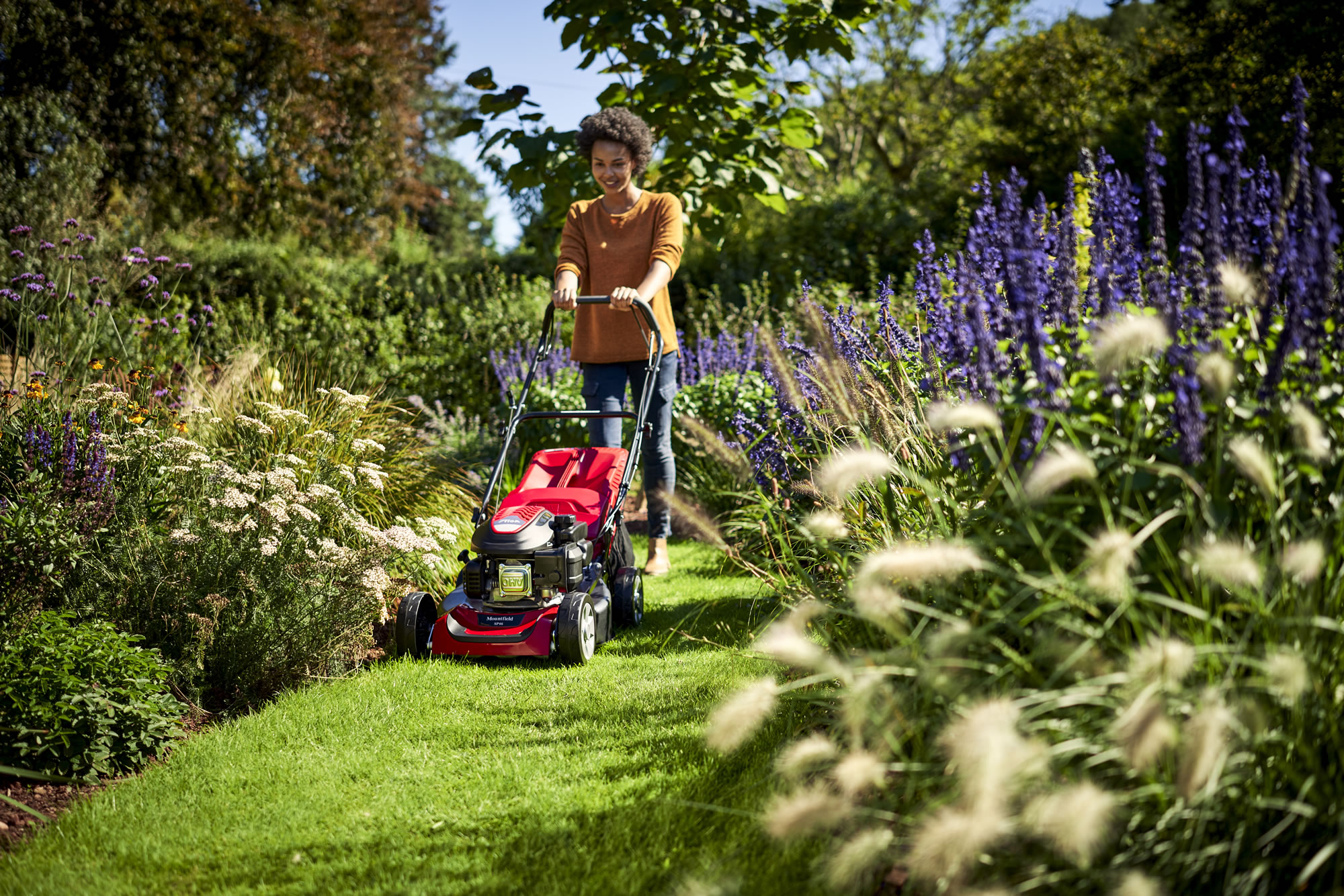 woman mowing lawn with walk behind mower